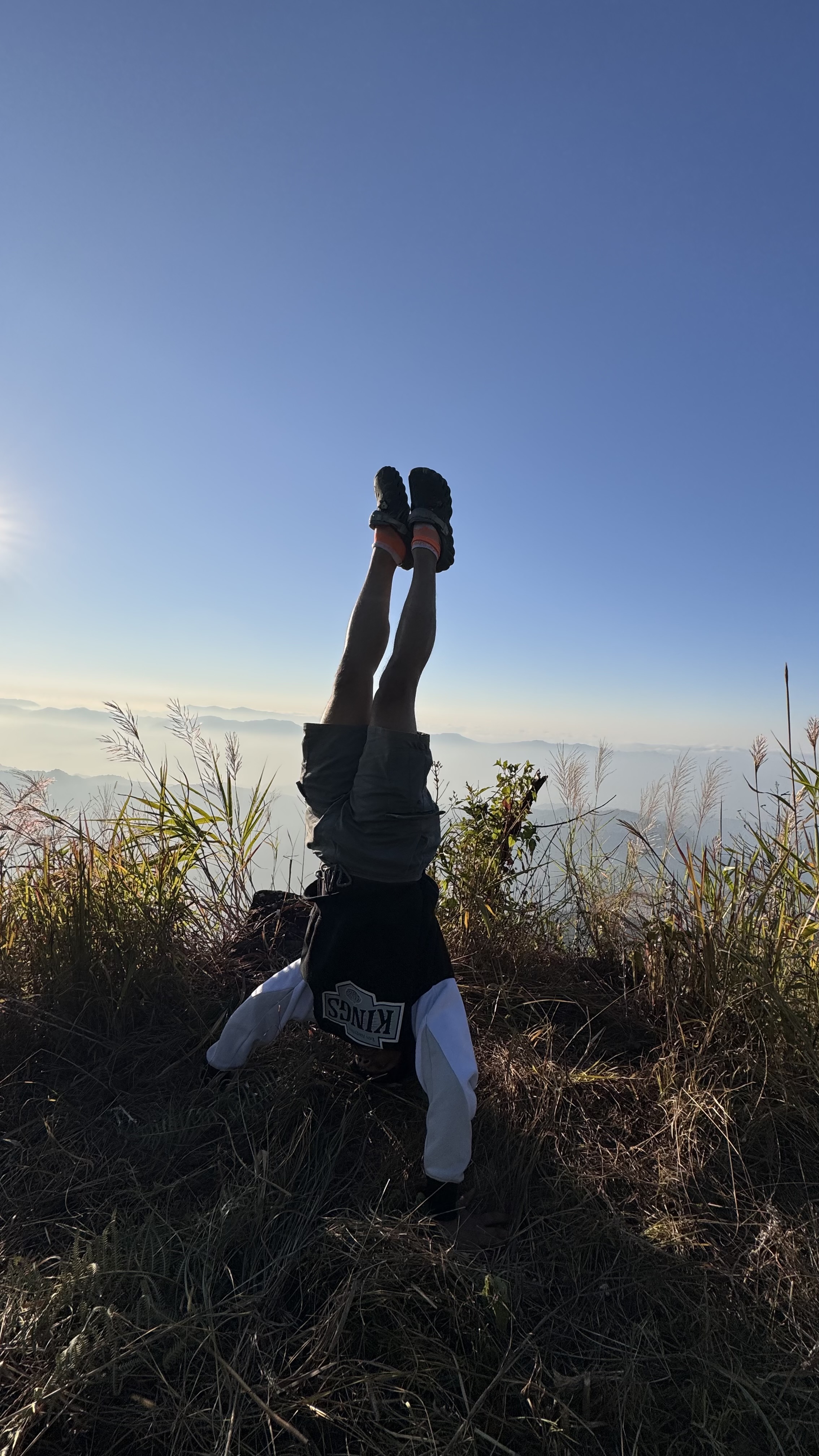 Aayush doing a headstand on a mountain trail